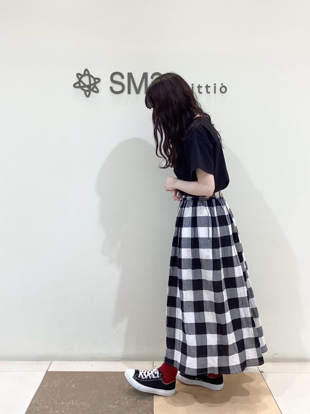 ブラック系のスカート、ブラック系のTシャツ/カットソーを着用したレディースの春コーディネートの2枚目の写真