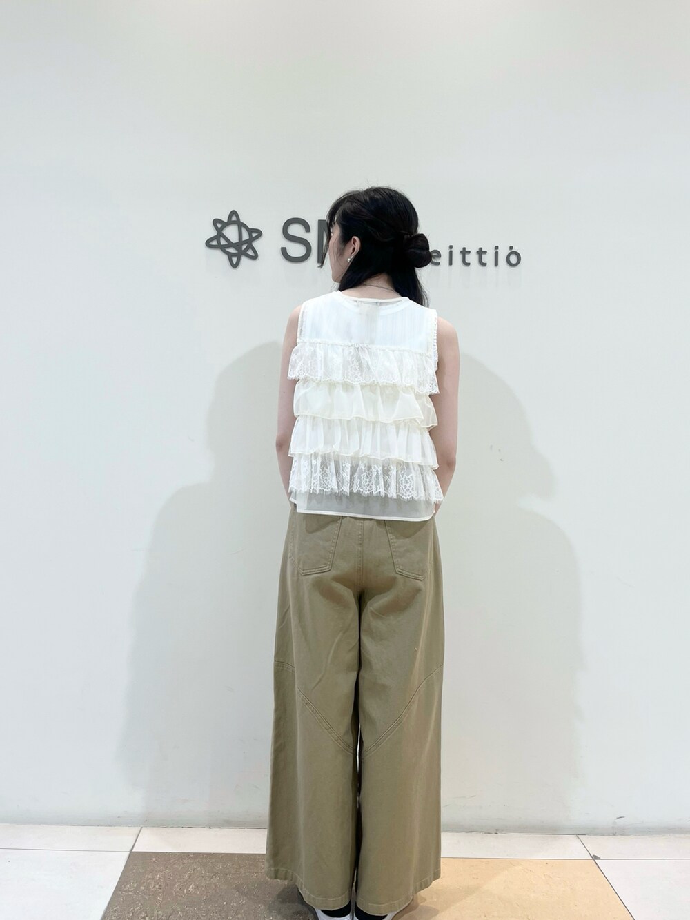 ホワイト系のベスト、ベージュ系のその他パンツを着用したレディースの夏コーディネートの2枚目の写真