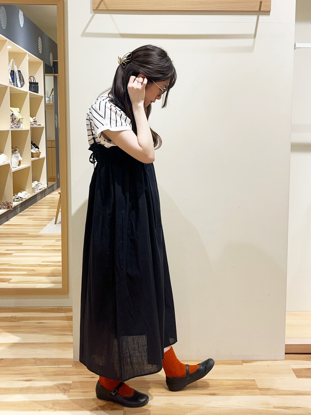 ブラック系のブーツ、ブラック系のワンピース、ブラック系のTシャツ/カットソーを着用したレディースの夏コーディネートの2枚目の写真