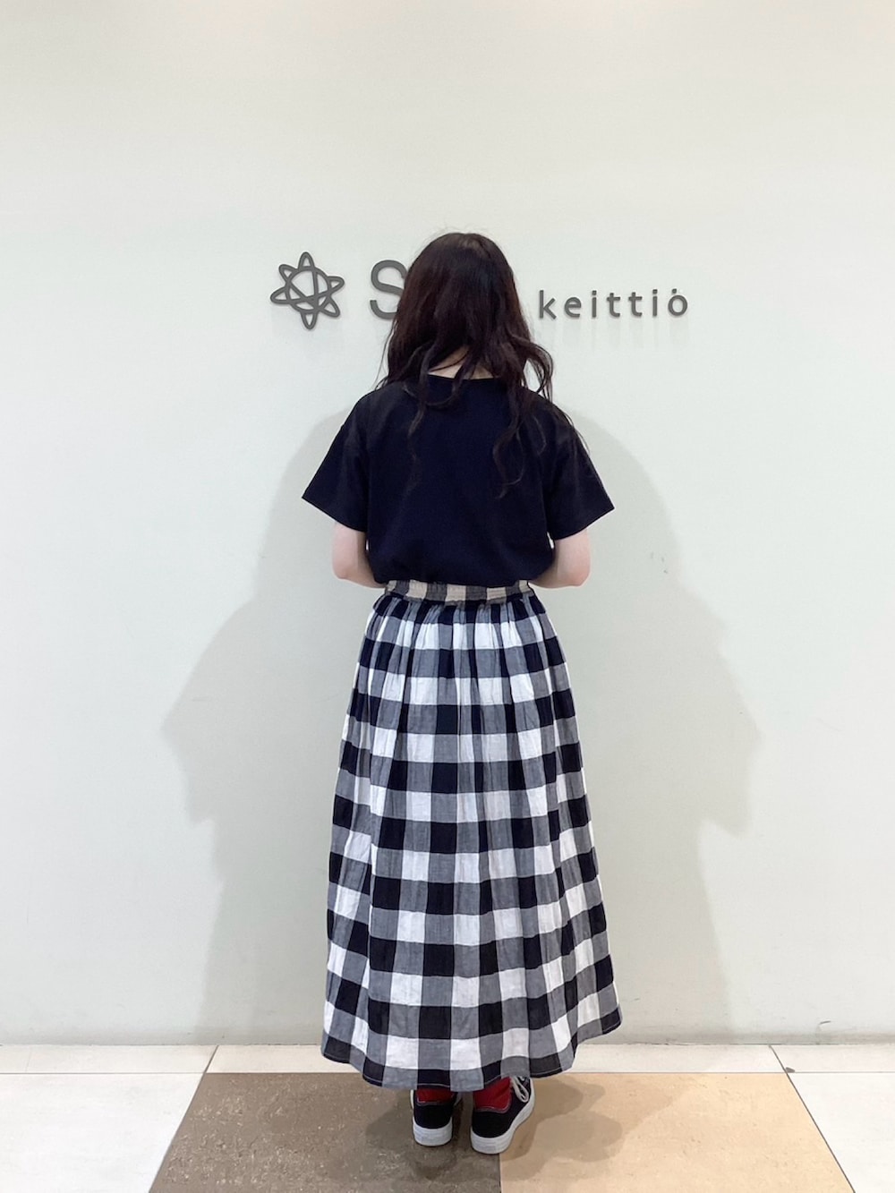 ブラック系のスカート、ブラック系のTシャツ/カットソーを着用したレディースの春コーディネートの3枚目の写真