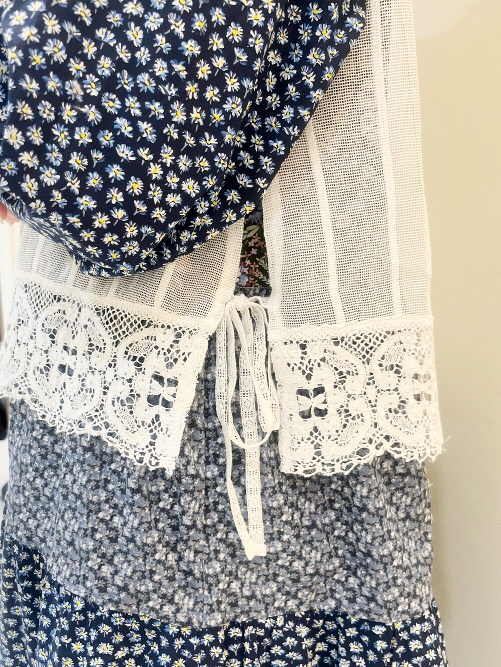 ブルー系のワンピース、ホワイト系のベストを着用したレディースの春コーディネートの4枚目の写真