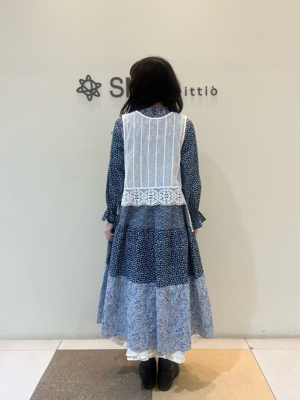 ブルー系のワンピース、ホワイト系のベストを着用したレディースの春コーディネートの3枚目の写真