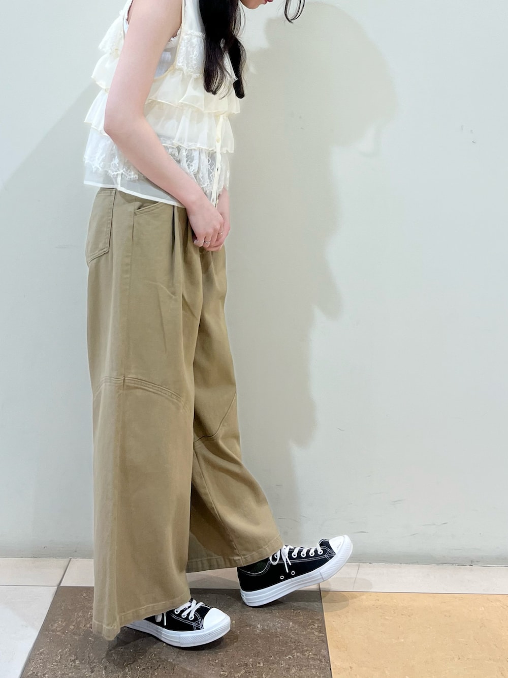 ホワイト系のベスト、ベージュ系のその他パンツを着用したレディースの夏コーディネートの3枚目の写真