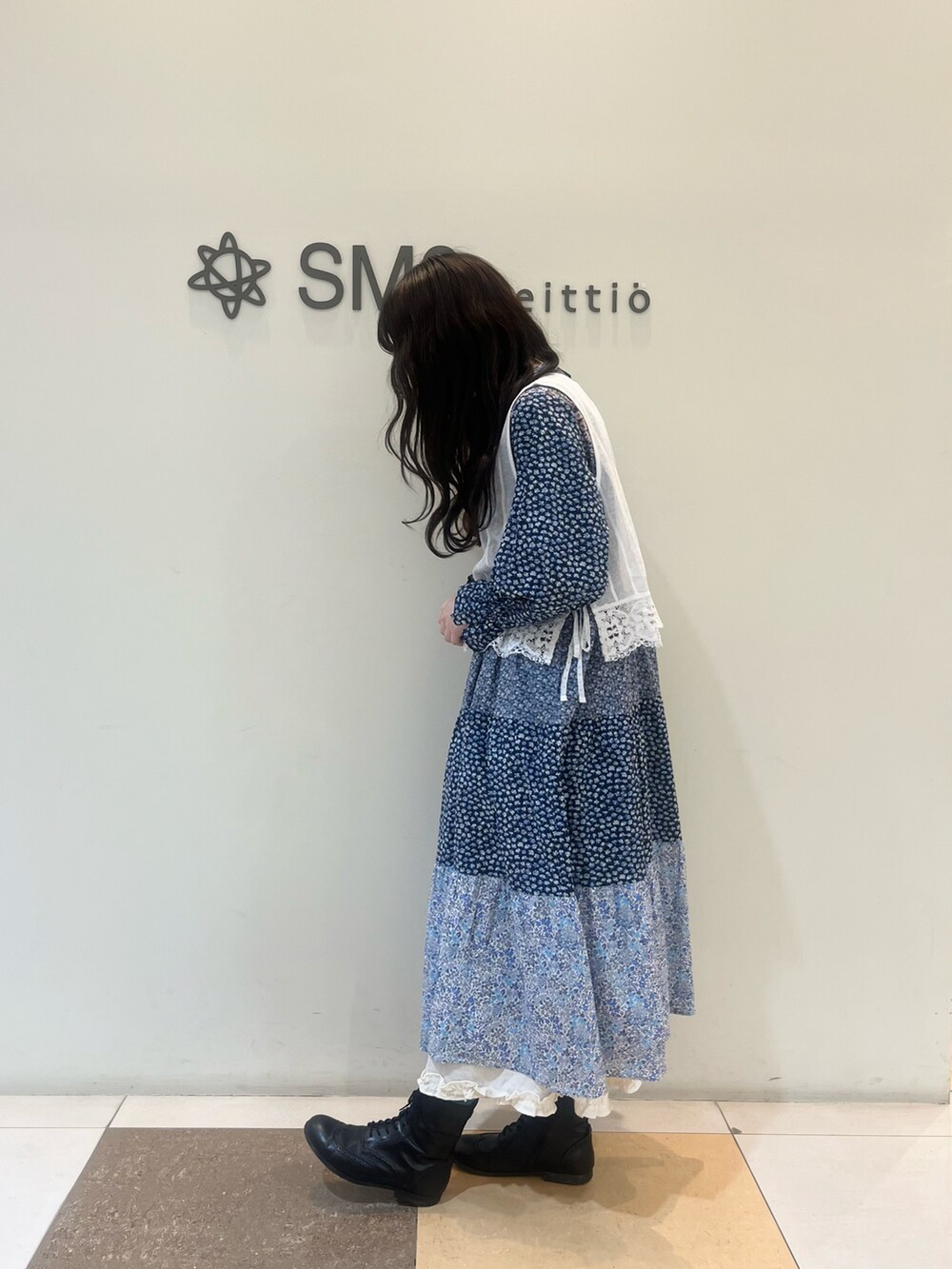 ブルー系のワンピース、ホワイト系のベストを着用したレディースの春コーディネートの2枚目の写真