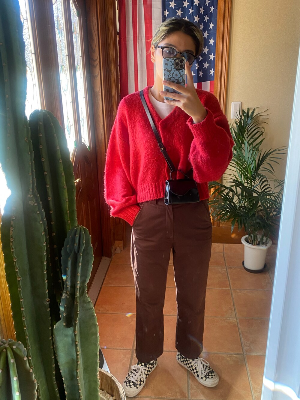 レッド系のカーディガン/ボレロ、ブラウン系のブルゾン、ブラウン系のパンツを着用したレディースの冬コーディネートの2枚目の写真