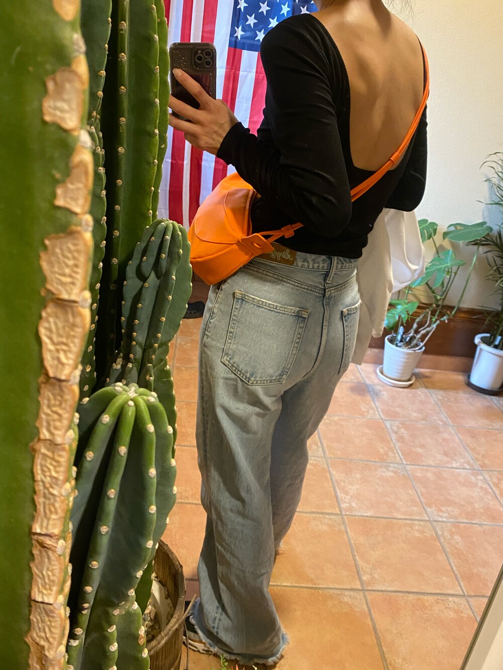 ブルー系のパンツ、オレンジ系のバッグ、ホワイト系のシャツ/ブラウスを着用したレディースの春コーディネートの2枚目の写真