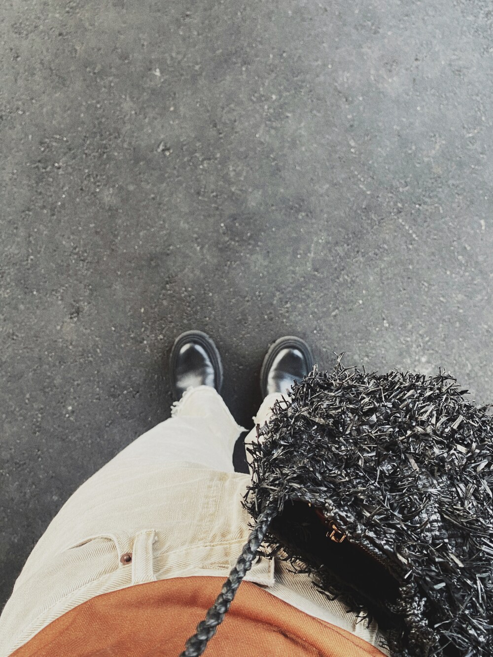 ベージュ系のデニムパンツ、ブラウン系のトップス、ブラック系のブーツを着用したレディースの春コーディネートの2枚目の写真