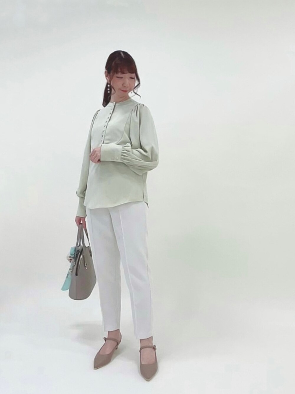 グリーン系のシャツ/ブラウス、ホワイト系のその他パンツ、ブラウン系のハンドバッグを着用したレディースの春コーディネートの2枚目の写真