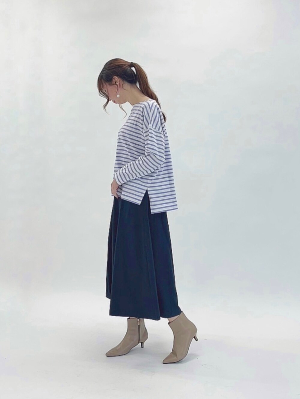 パープル系のTシャツ/カットソー、イエロー系のハンドバッグ、ブルー系のスカートを着用したレディースの春コーディネートの2枚目の写真