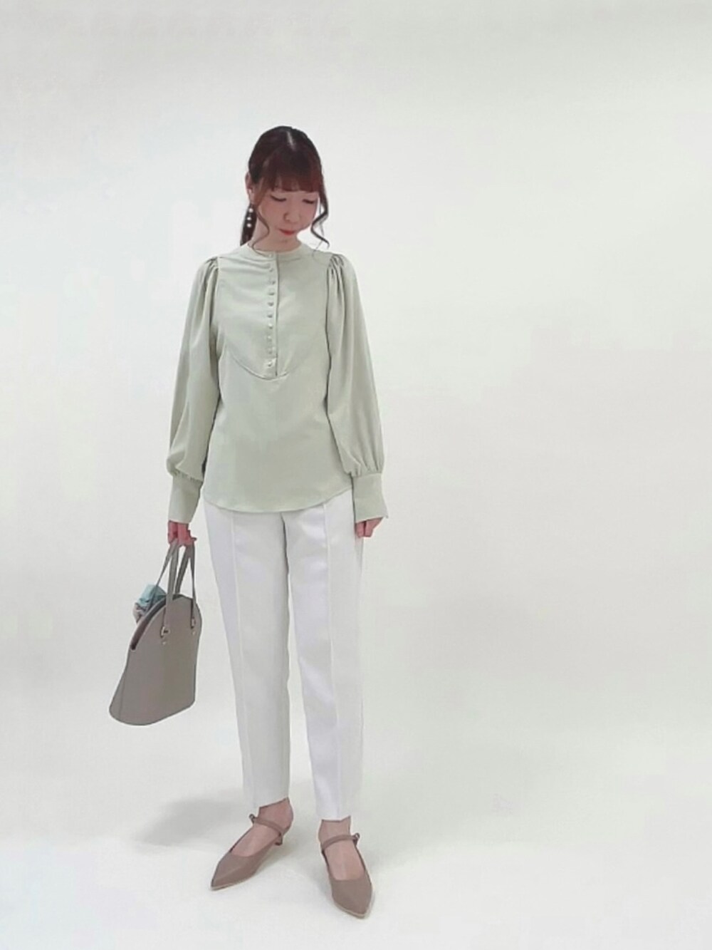 グリーン系のシャツ/ブラウス、ホワイト系のその他パンツ、ブラウン系のハンドバッグを着用したレディースの春コーディネートの3枚目の写真