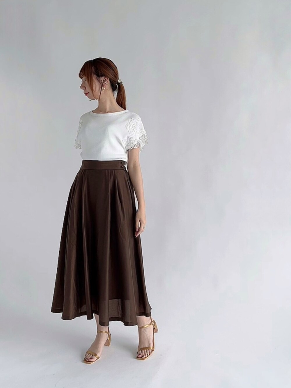 ブルー系のニット/セーター、ピンク系のスカート、グレー系のトートバッグを着用したレディースの夏コーディネートの2枚目の写真