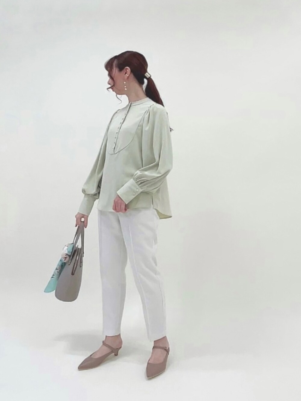 グリーン系のシャツ/ブラウス、ホワイト系のその他パンツ、ブラウン系のハンドバッグを着用したレディースの春コーディネートの4枚目の写真