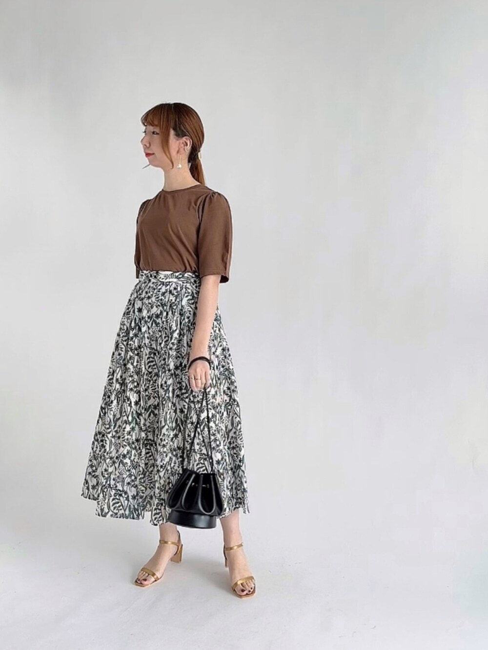 ホワイト系のニット/セーター、ブラウン系のその他パンツ、イエロー系のショルダーバッグを着用したレディースの秋コーディネートの2枚目の写真