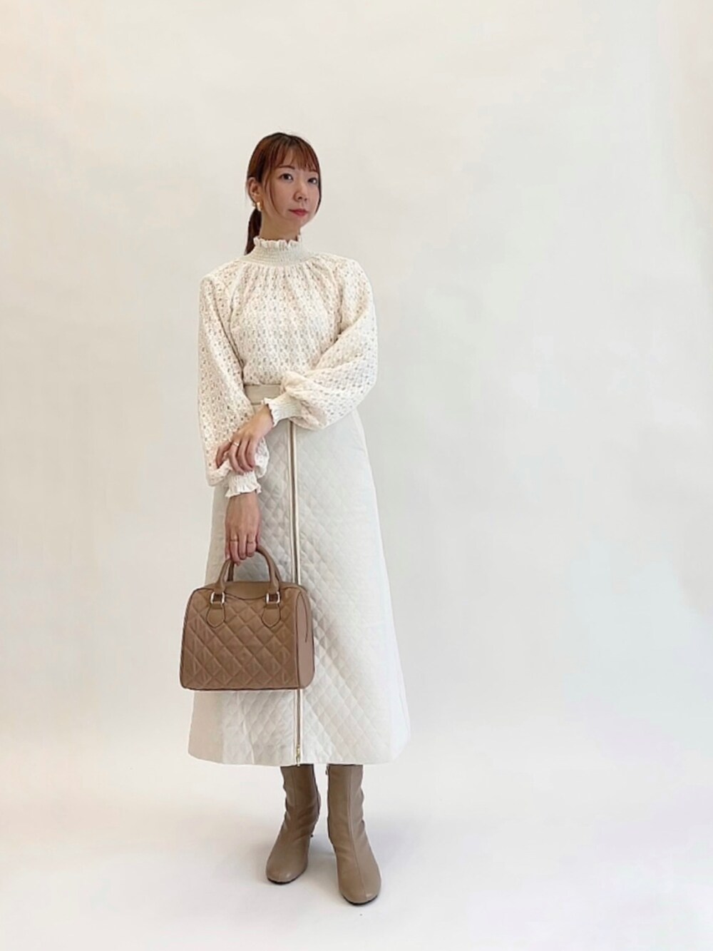 ホワイト系のシャツ/ブラウス、ブラック系のノーカラージャケット、ホワイト系のスカートを着用したレディースの冬コーディネートの2枚目の写真