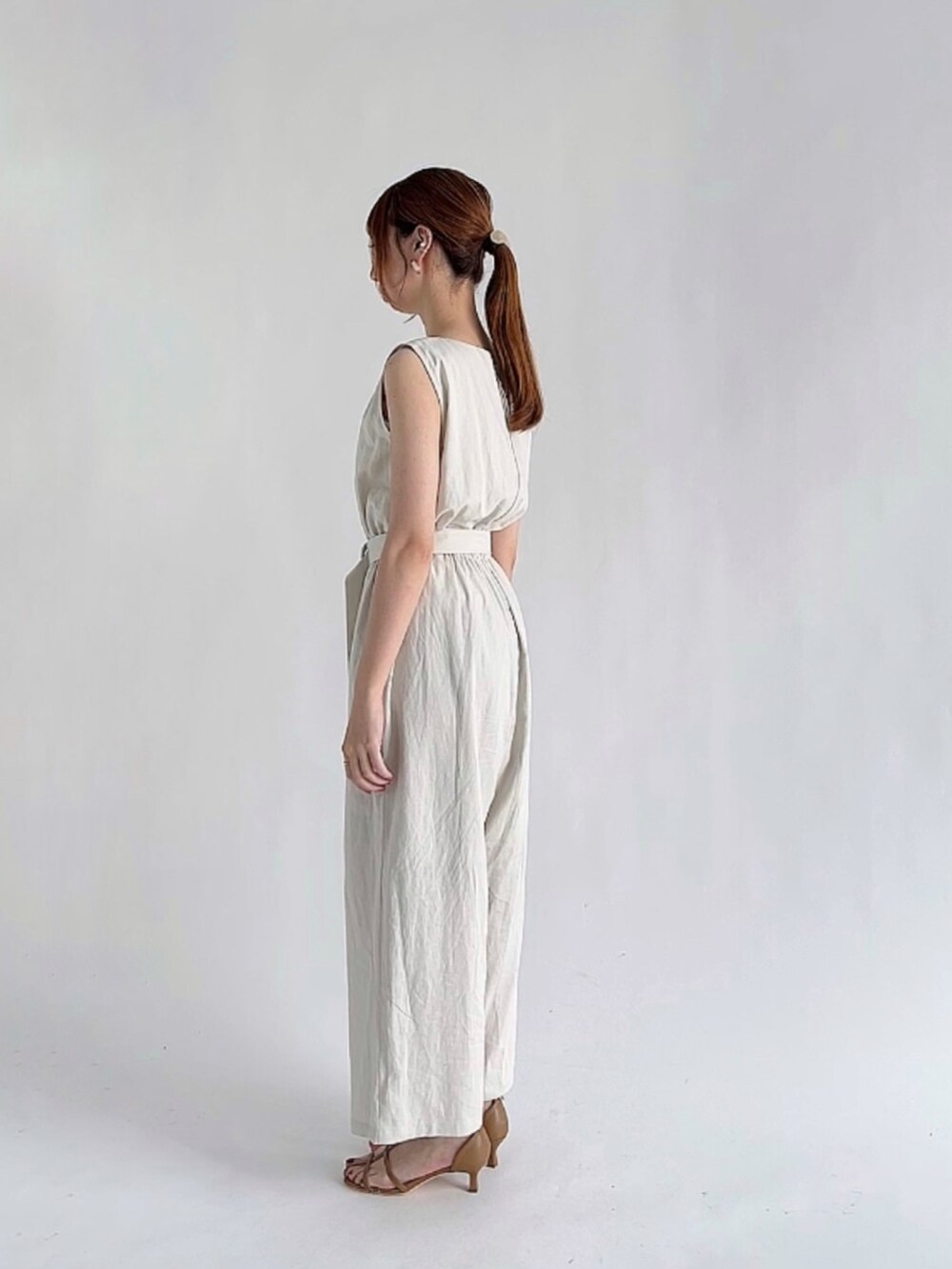 ホワイト系のその他パンツ、ブラック系のアンサンブル、ブラウン系のサンダルを着用したレディースの夏コーディネートの3枚目の写真