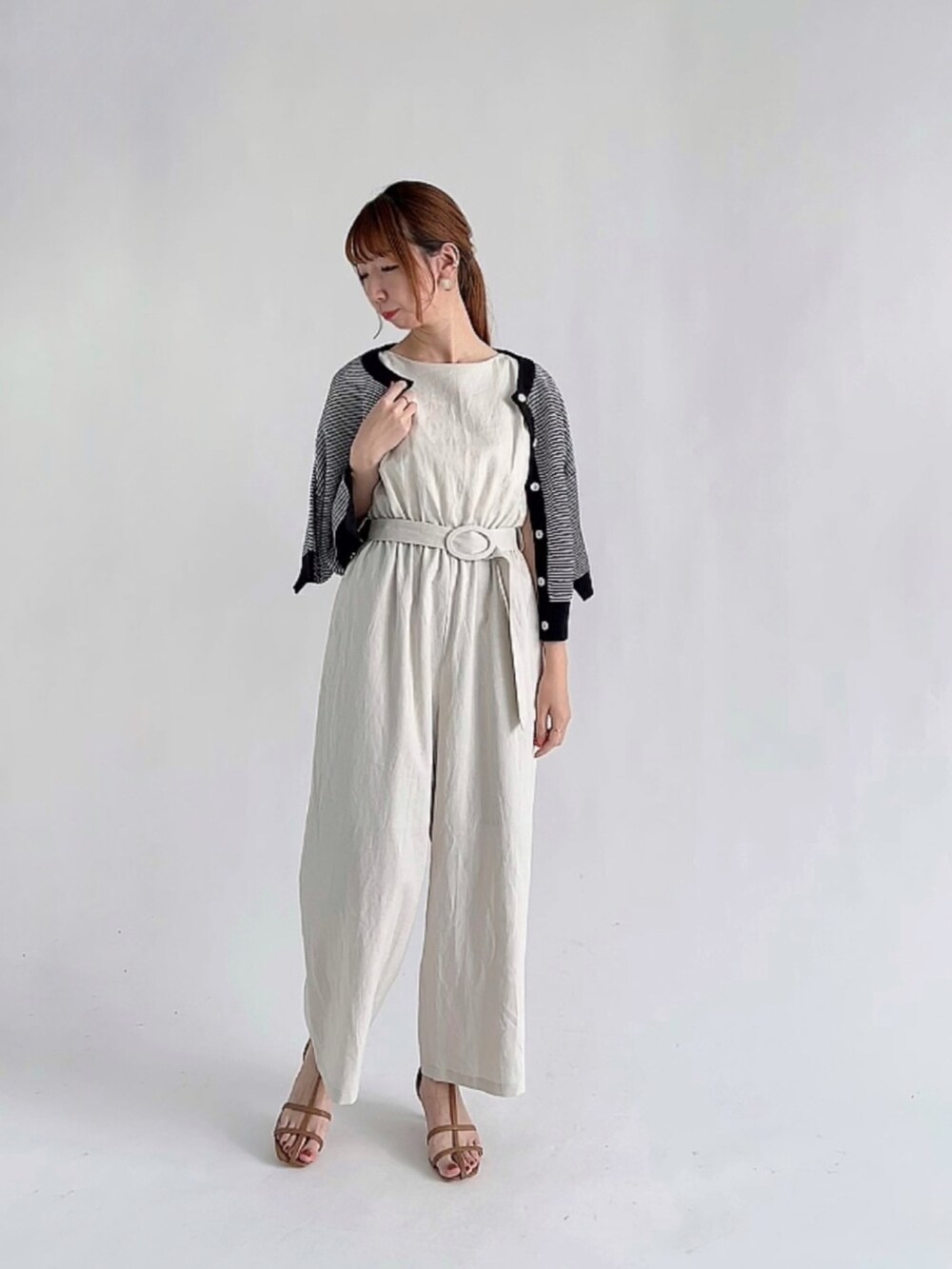 ホワイト系のその他パンツ、ブラック系のアンサンブル、ブラウン系のサンダルを着用したレディースの夏コーディネートの2枚目の写真