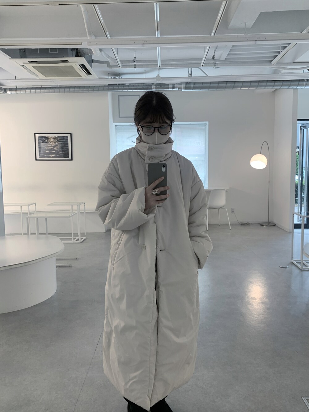 ホワイト系のダウンジャケット/コート、ブラウン系のトートバッグ、ブラック系のブーツを着用したレディースの冬コーディネートの2枚目の写真