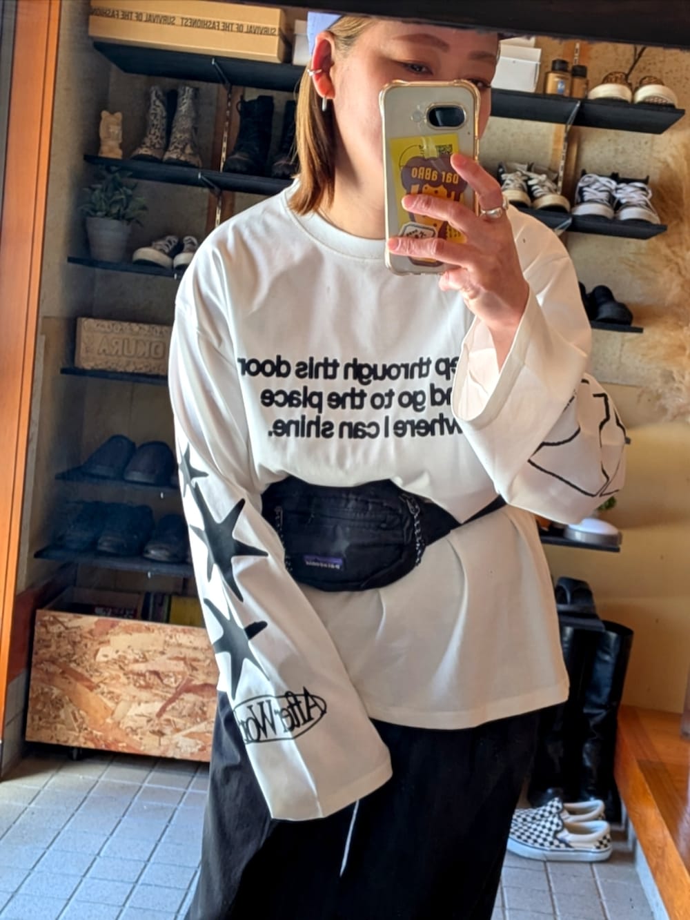 ホワイト系のTシャツ/カットソー、ブラック系のメッセンジャーバッグ、グレー系のスニーカーを着用したレディースの春コーディネートの2枚目の写真