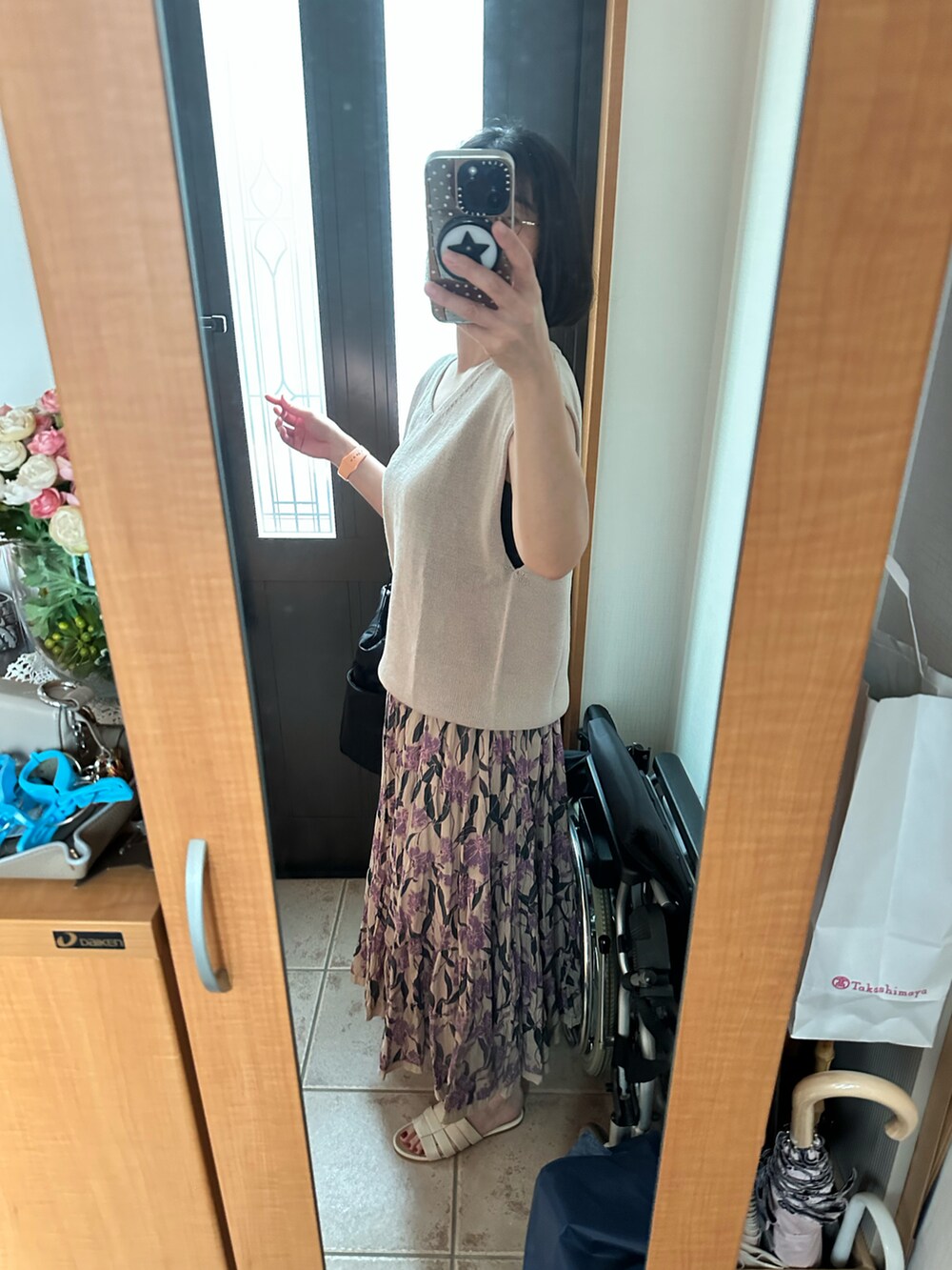 ベージュ系のニット/セーター、ベージュ系のスカート、ホワイト系のサンダルを着用したレディースの夏コーディネートの2枚目の写真