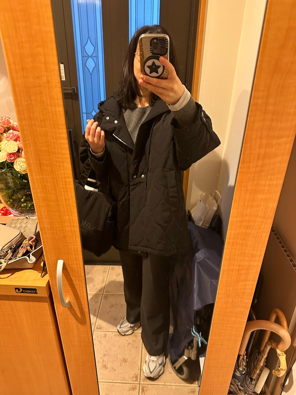 グレー系のスラックス、ブラック系のトートバッグ、グレー系のニット/セーターを着用したレディースの冬コーディネートの3枚目の写真