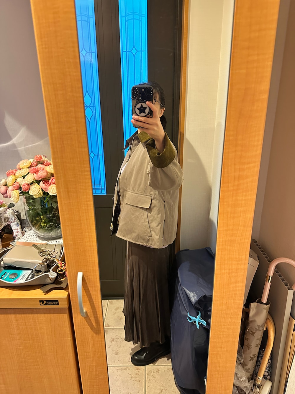 ベージュ系のその他アウター、パープル系のニット/セーター、ブラウン系のスカートを着用したレディースの秋コーディネートの4枚目の写真