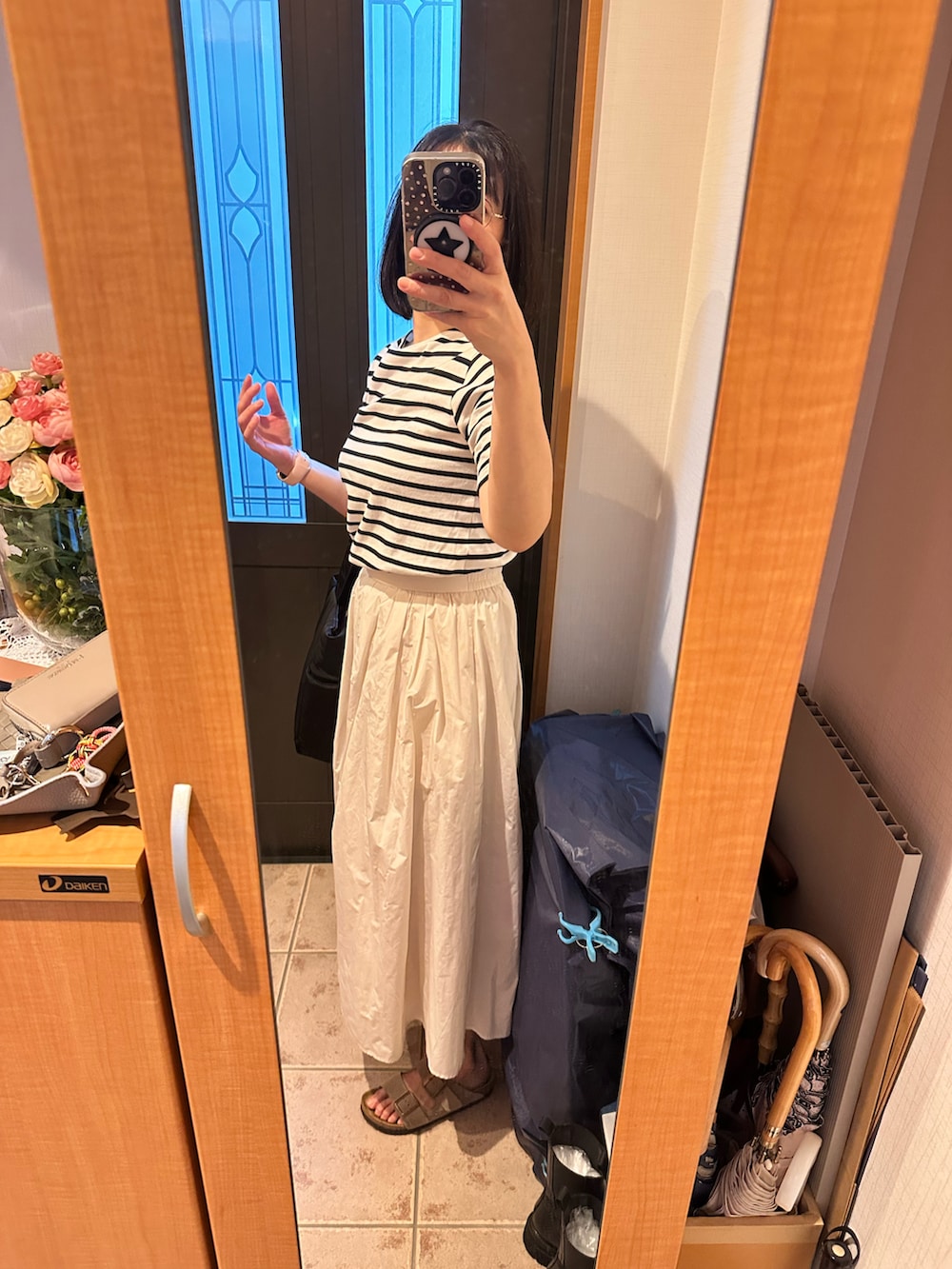 ブラック系のTシャツ/カットソー、ホワイト系のスカート、その他のシューズを着用したレディースの秋コーディネートの2枚目の写真