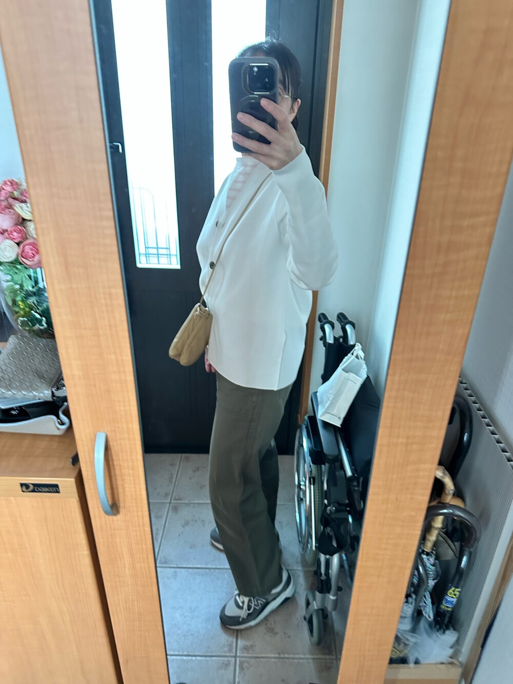 ホワイト系のカーディガン/ボレロ、ピンク系のTシャツ/カットソー、ベージュ系のショルダーバッグを着用したレディースの春コーディネートの2枚目の写真