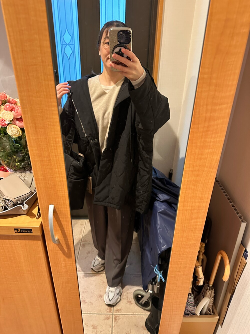 ベージュ系のニット/セーター、ホワイト系のTシャツ/カットソー、ブラック系のトートバッグを着用したレディースの冬コーディネートの3枚目の写真