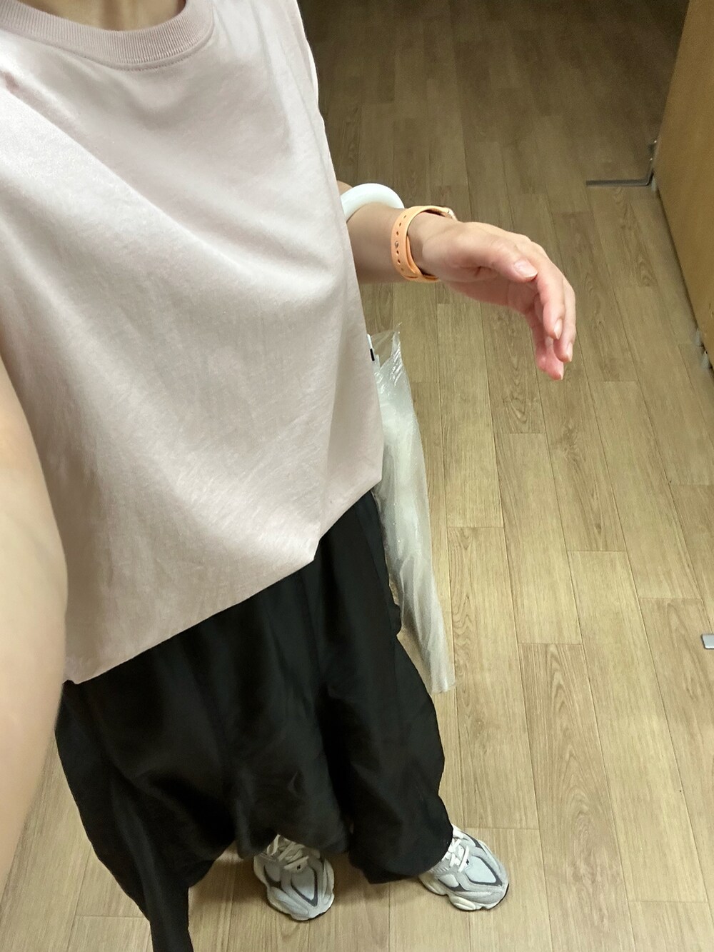 ピンク系のTシャツ/カットソー、ブラック系のスカート、グレー系のスニーカーを着用したレディースの秋コーディネートの3枚目の写真