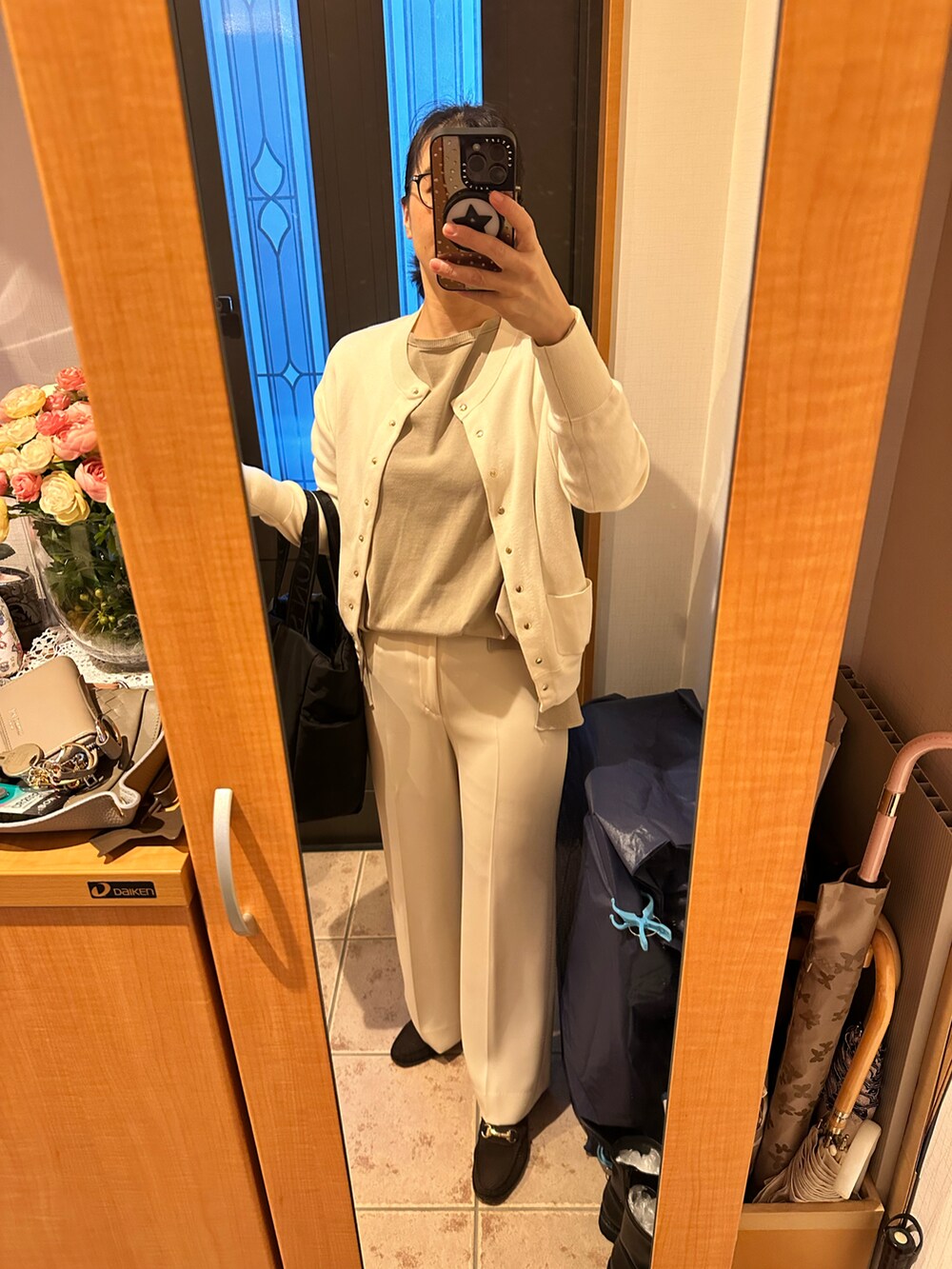 ベージュ系のその他アウター、ベージュ系のニット/セーター、ホワイト系のカーディガン/ボレロを着用したレディースの秋コーディネートの4枚目の写真