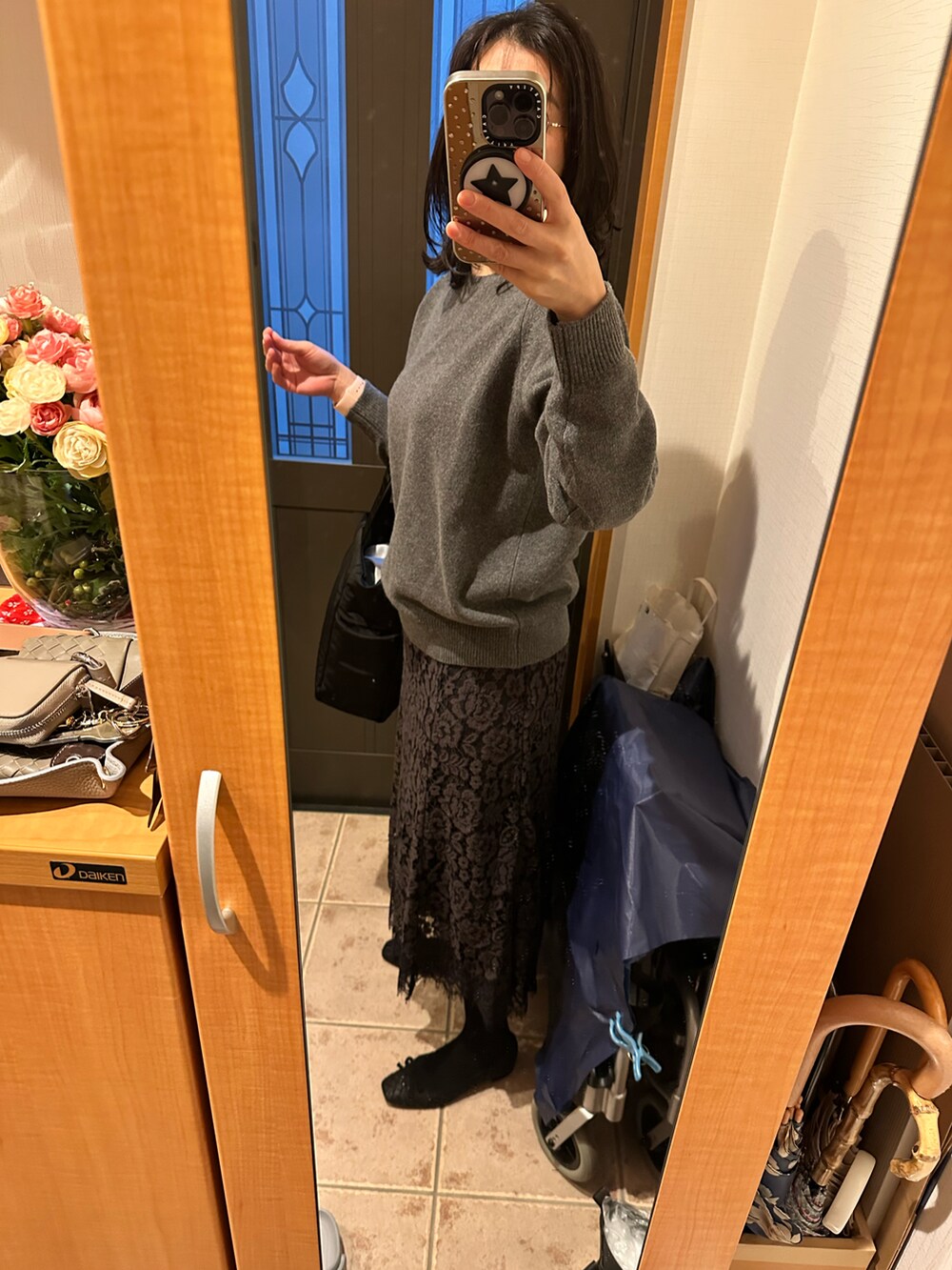 グレー系のニット/セーター、ベージュ系のダウンジャケット/コート、ブラック系のシューズを着用したレディースの冬コーディネートの2枚目の写真