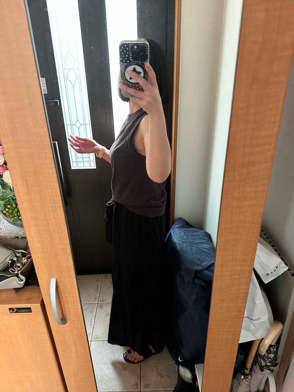 ブラウン系のタンクトップ、ブラック系のスカート、ブラック系のサンダルを着用したレディースの夏コーディネートの2枚目の写真