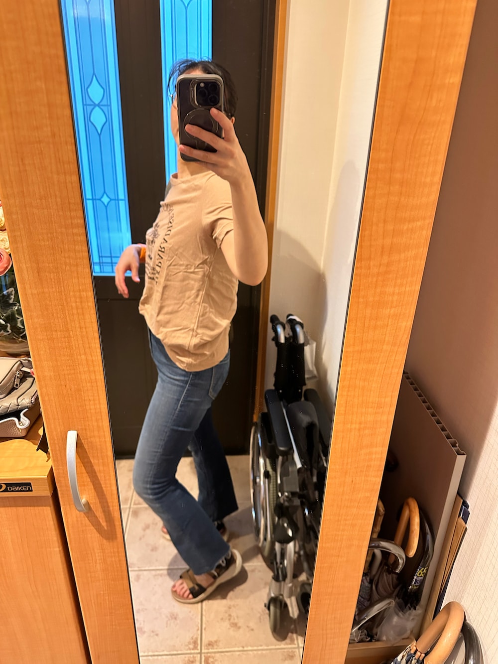 ベージュ系のTシャツ/カットソー、ブルー系のデニムパンツ、イエロー系のサンダルを着用したレディースの夏コーディネートの2枚目の写真