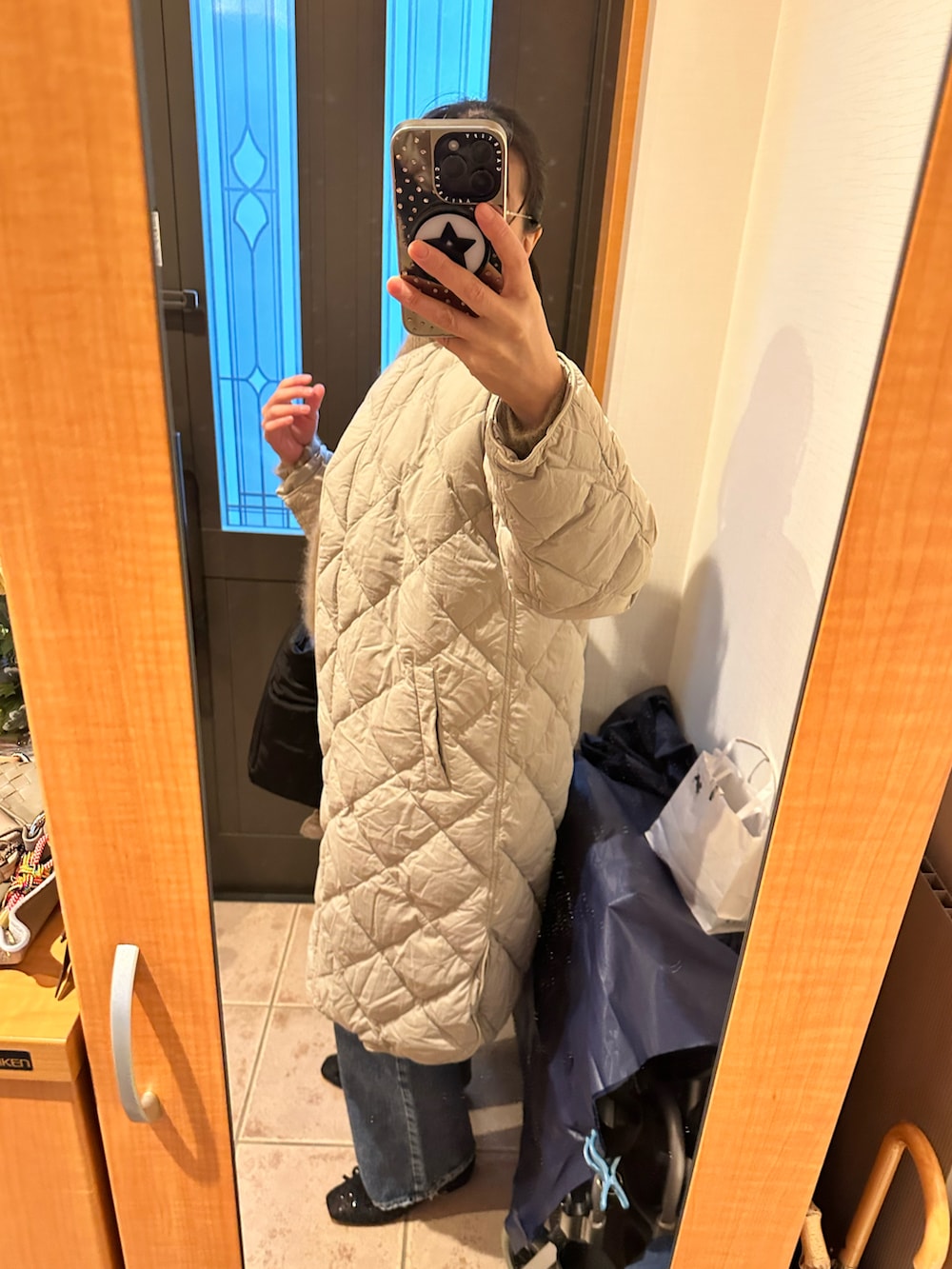 ブラウン系のニット/セーター、ブラック系のトートバッグ、ブルー系のデニムパンツを着用したレディースの冬コーディネートの4枚目の写真