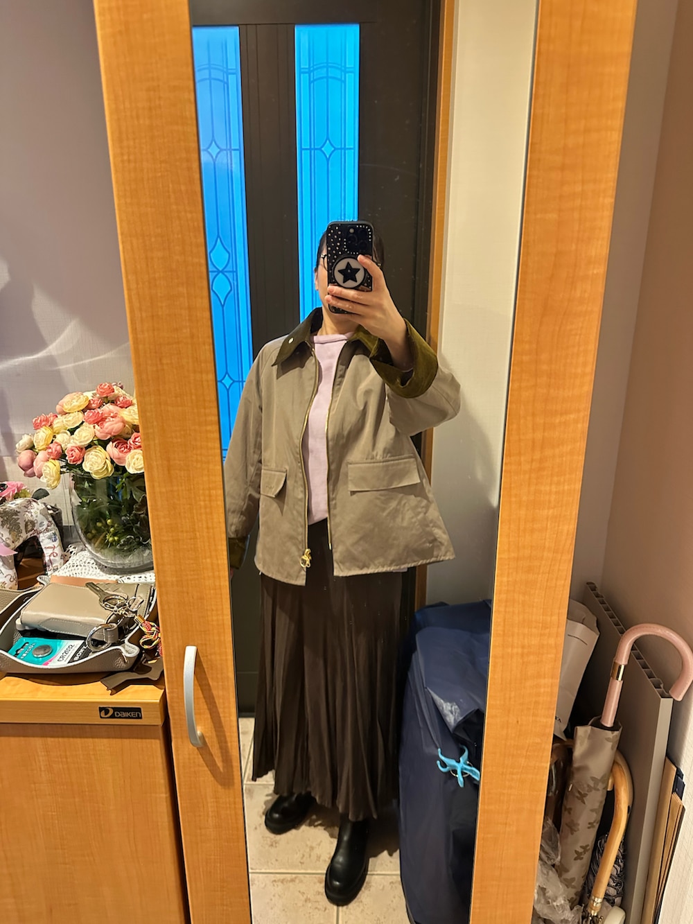 ベージュ系のその他アウター、パープル系のニット/セーター、ブラウン系のスカートを着用したレディースの秋コーディネートの3枚目の写真