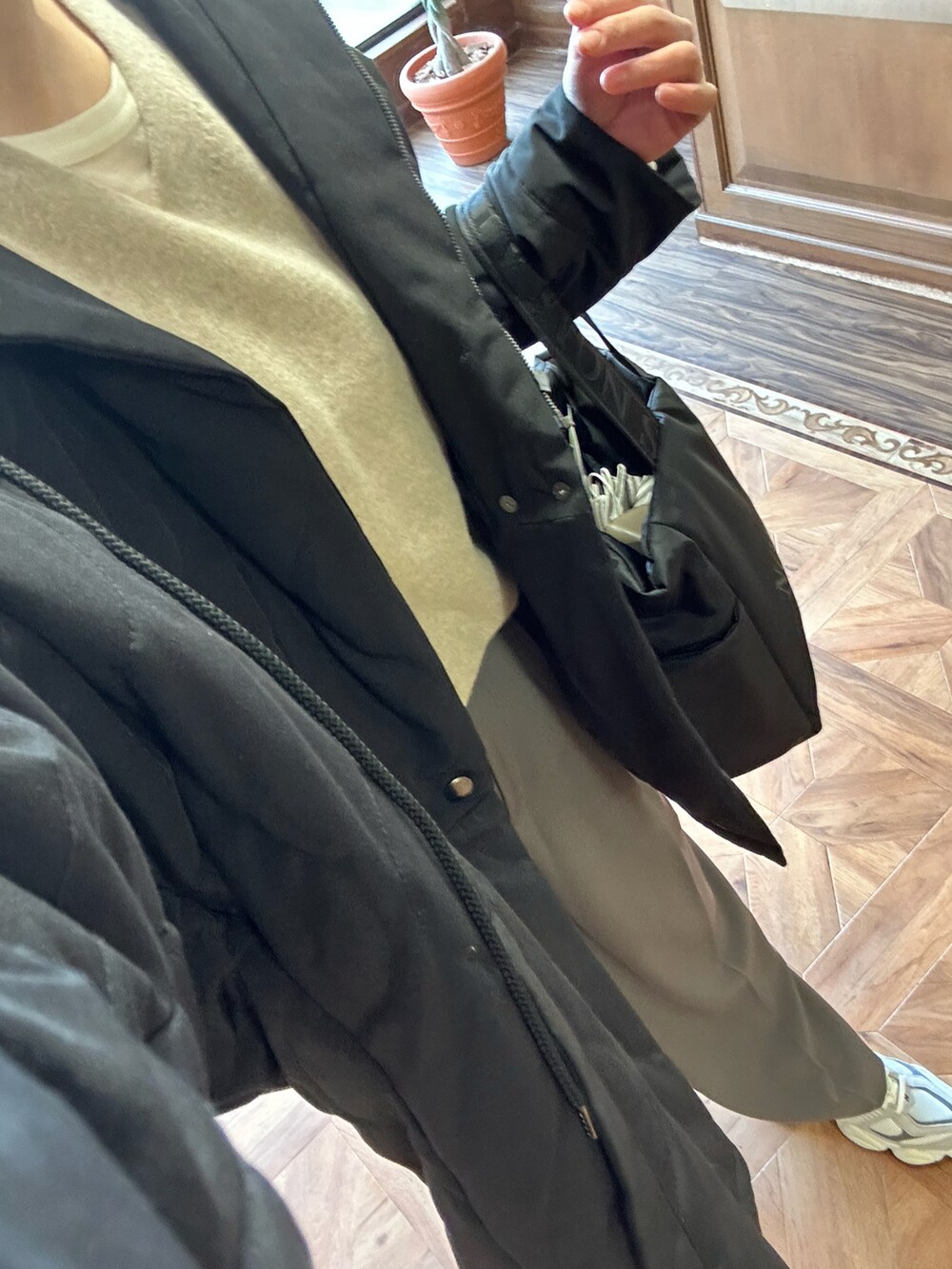 ベージュ系のニット/セーター、ホワイト系のTシャツ/カットソー、ブラック系のトートバッグを着用したレディースの冬コーディネートの5枚目の写真