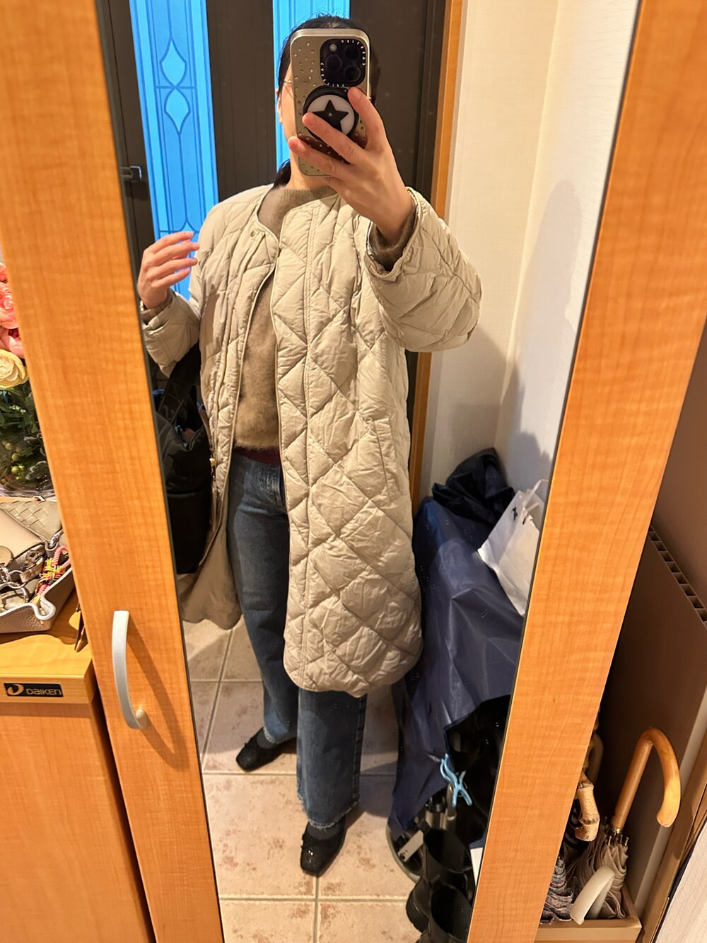 ブラウン系のニット/セーター、ブラック系のトートバッグ、ブルー系のデニムパンツを着用したレディースの冬コーディネートの3枚目の写真