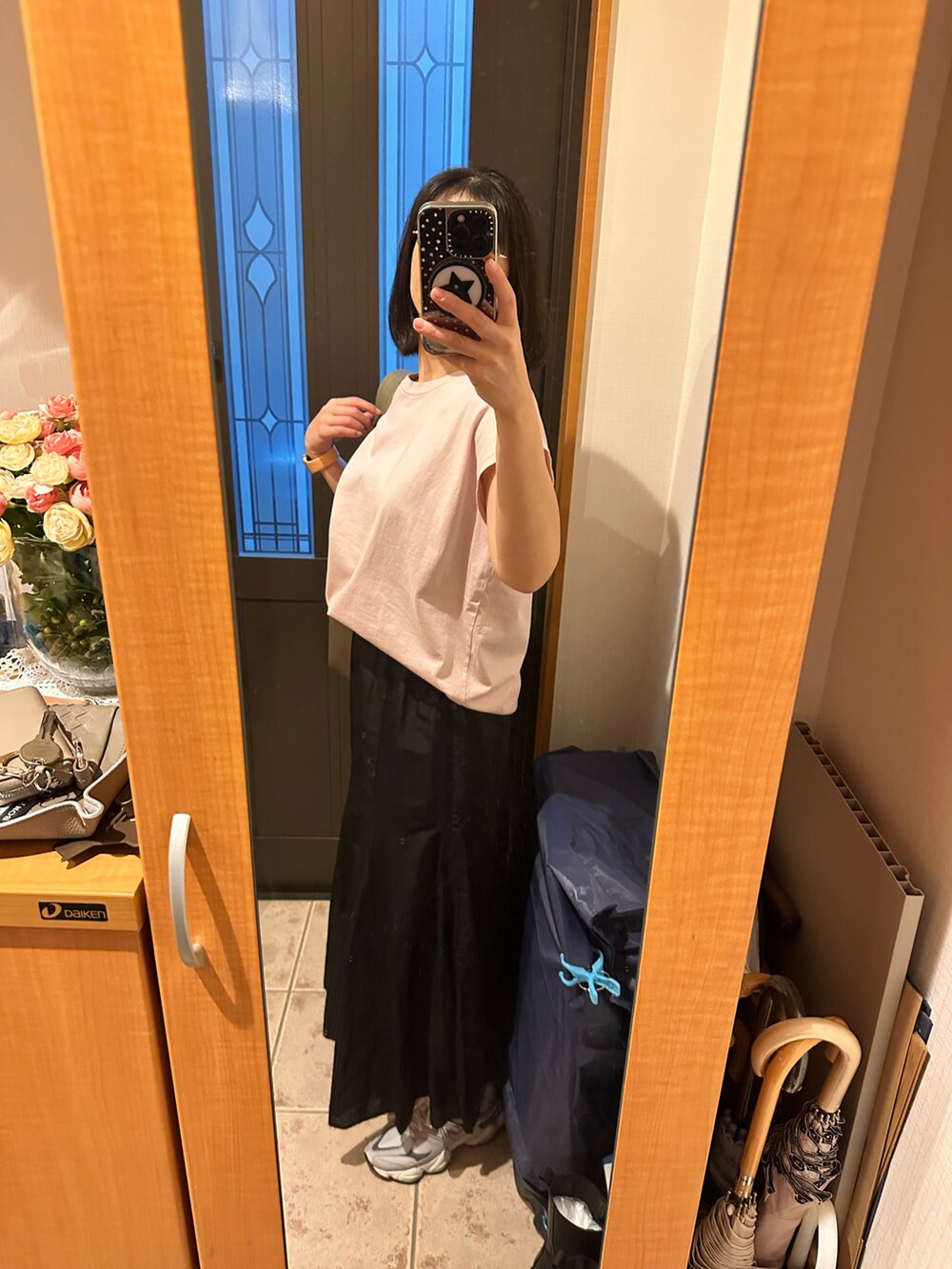 ピンク系のTシャツ/カットソー、ブラック系のスカート、グレー系のスニーカーを着用したレディースの秋コーディネートの2枚目の写真