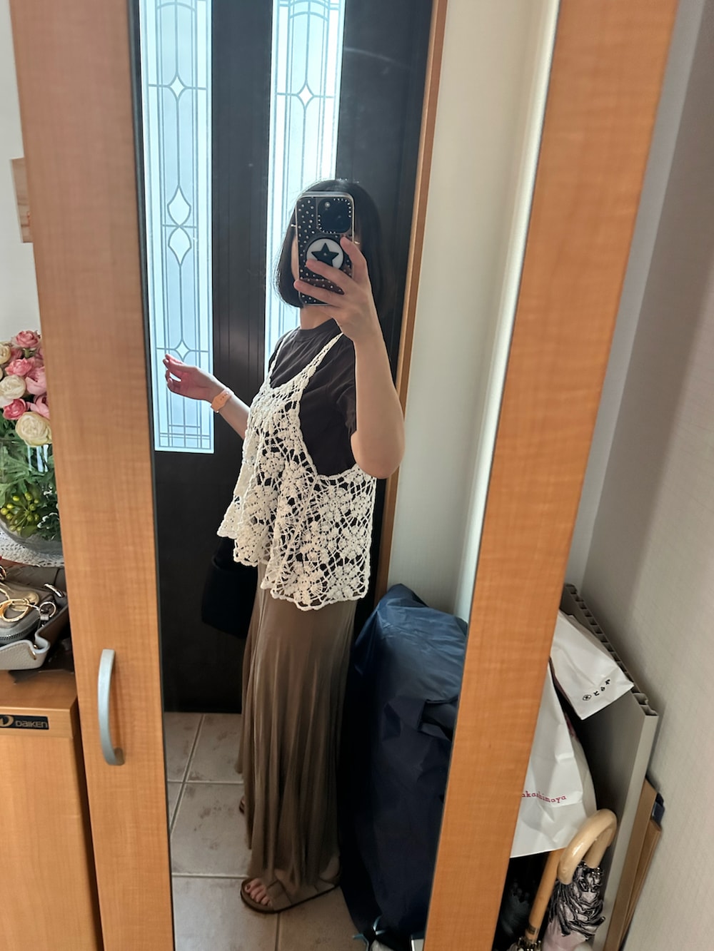 ベージュ系のスカート、ホワイト系のニット/セーター、ブラウン系のTシャツ/カットソーを着用したレディースの夏コーディネートの2枚目の写真