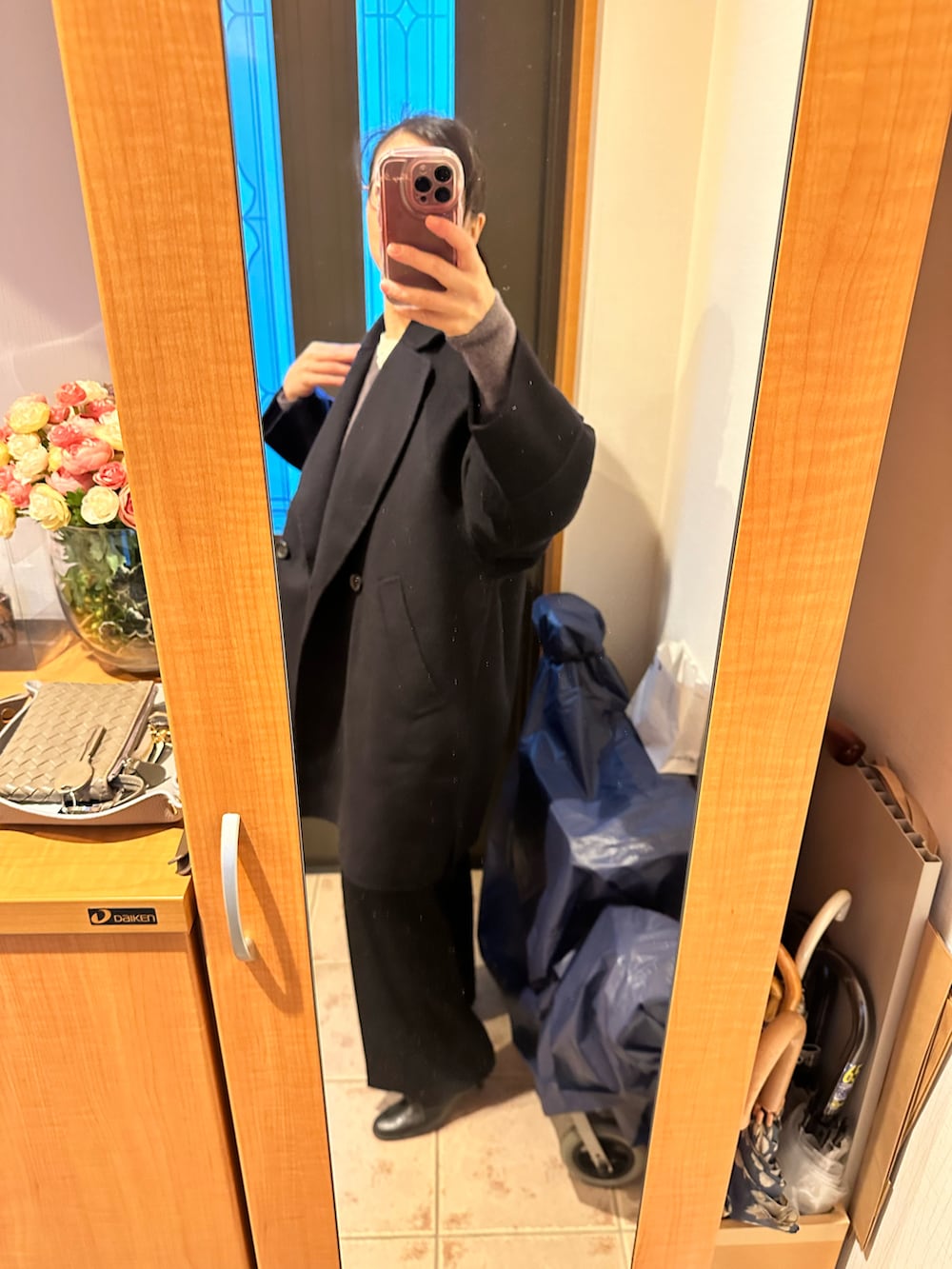 ブルー系のその他アウター、グレー系のニット/セーター、ブラック系のスラックスを着用したレディースの冬コーディネートの2枚目の写真