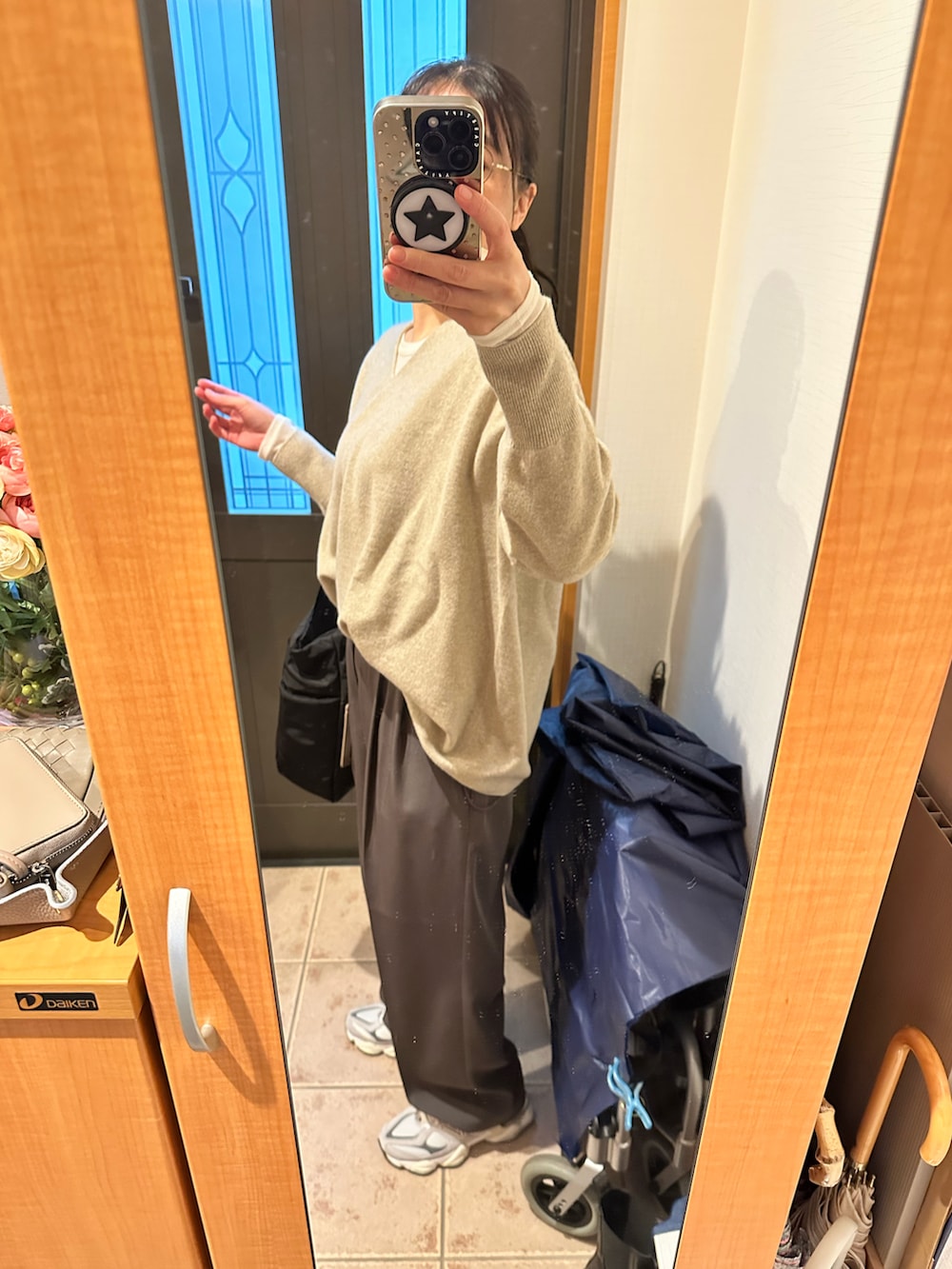 ベージュ系のニット/セーター、ホワイト系のTシャツ/カットソー、ブラック系のトートバッグを着用したレディースの冬コーディネートの2枚目の写真