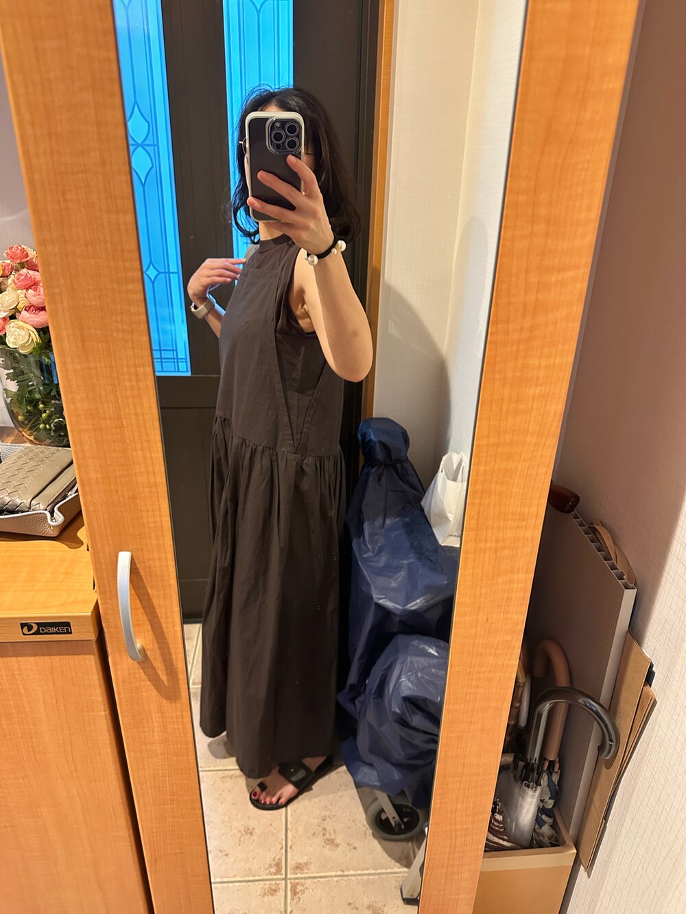 グレー系のワンピース、ブラウン系のタンクトップ、ブラック系のサンダルを着用したレディースの夏コーディネートの2枚目の写真