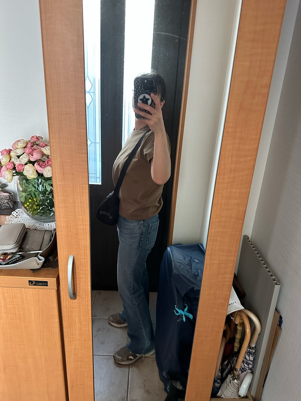 ブラウン系のTシャツ/カットソー、ブルー系のデニムパンツ、ベージュ系のスニーカーを着用したレディースの秋コーディネートの2枚目の写真