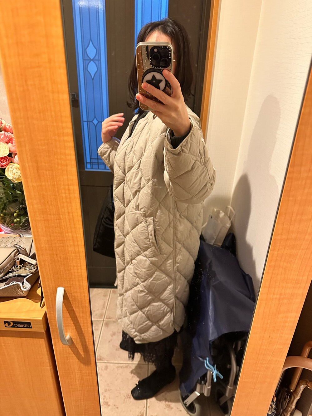 グレー系のニット/セーター、ベージュ系のダウンジャケット/コート、ブラック系のシューズを着用したレディースの冬コーディネートの4枚目の写真