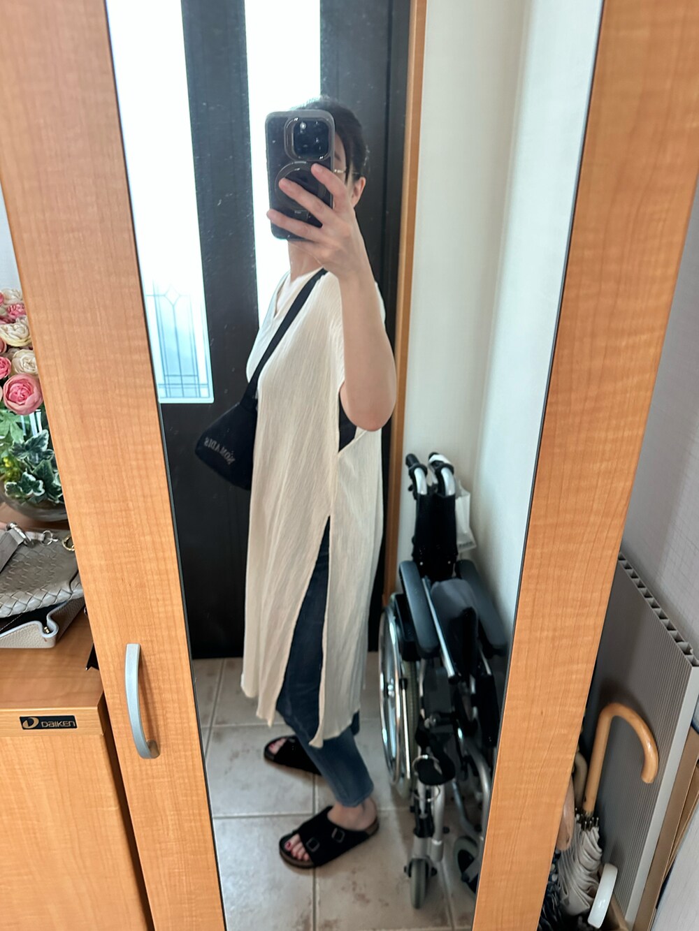 ブラック系のショルダーバッグ、ホワイト系のワンピース/ドレス、ブラック系のサンダルを着用したレディースの夏コーディネートの2枚目の写真