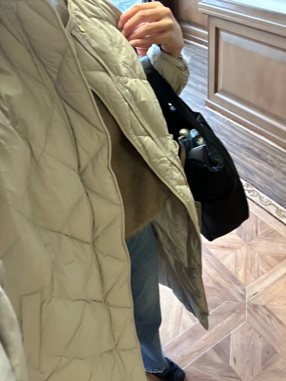 ブラウン系のニット/セーター、ブラック系のトートバッグ、ブルー系のデニムパンツを着用したレディースの冬コーディネートの5枚目の写真