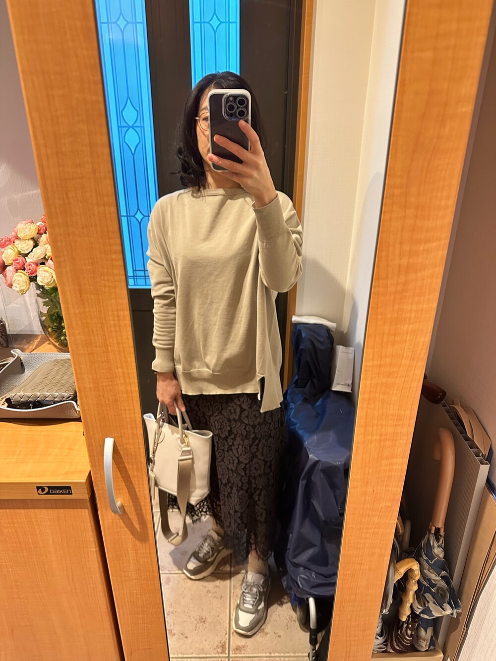 ブルー系のその他アウター、ベージュ系のニット/セーター、ホワイト系のバッグを着用したレディースの春コーディネートの3枚目の写真