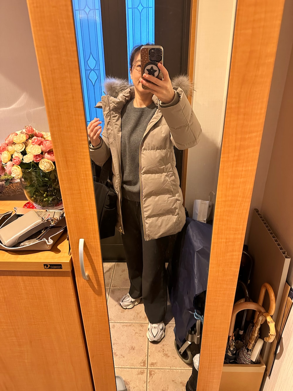 グレー系のニット/セーター、ブラック系のトートバッグ、グレー系のスラックスを着用したレディースの冬コーディネートの3枚目の写真