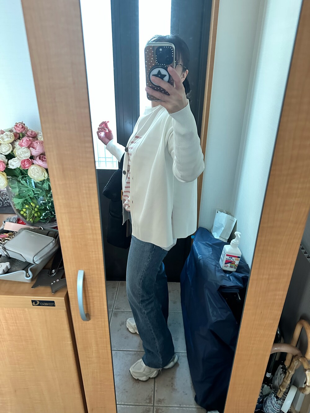 ホワイト系のカーディガン/ボレロ、ピンク系のTシャツ/カットソー、ブルー系のデニムパンツを着用したレディースの春コーディネートの2枚目の写真