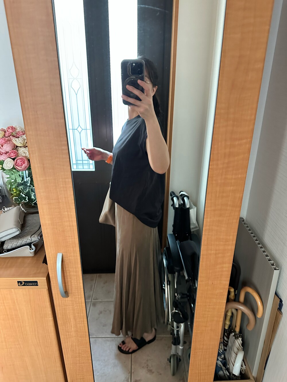 ブラック系のTシャツ/カットソー、ベージュ系のスカート、ベージュ系のトートバッグを着用したレディースの夏コーディネートの2枚目の写真